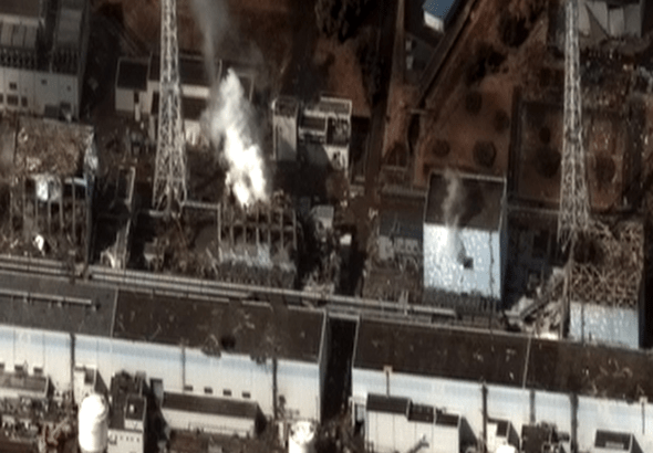 Vue aérienne d'une centrale nucléaire endommagée d'où s'échappe de la fumée