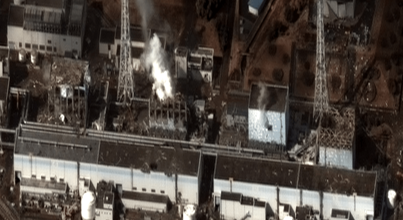 Vue aérienne d'une centrale nucléaire endommagée d'où s'échappe de la fumée