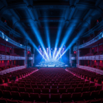 Salle de concert vide illuminée par des faisceaux de lumière bleus dirigés vers la scène